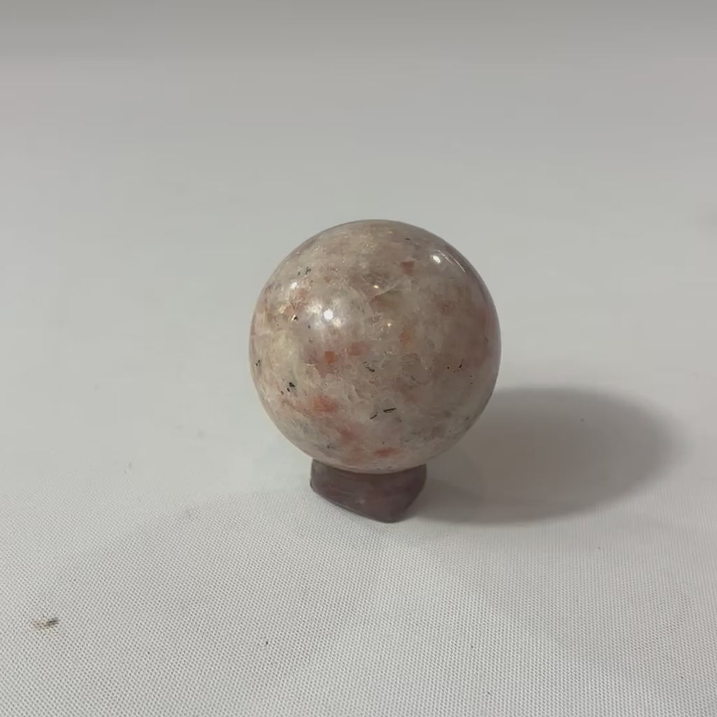 Sunstone Polished Crystal Sphere on a Small Quartz Crystal Stand. Free express shipping. Shop online from ASH&STONE crystal shop Auckland NZ. AfterPay available.
