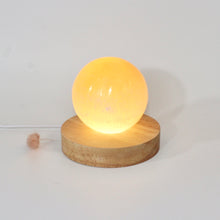 Load image into Gallery viewer, Orange selenite crystal sphere lamp on LED wooden base | ASH&amp;STONE Crystals Shop Auckland NZ
